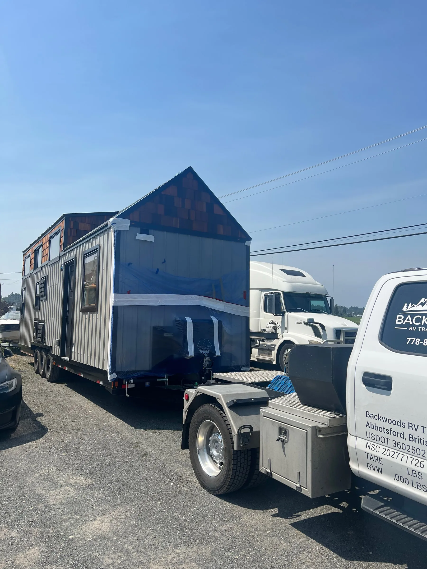 A wrapped tiny home hitched to a Backwoods truck, ready to tow